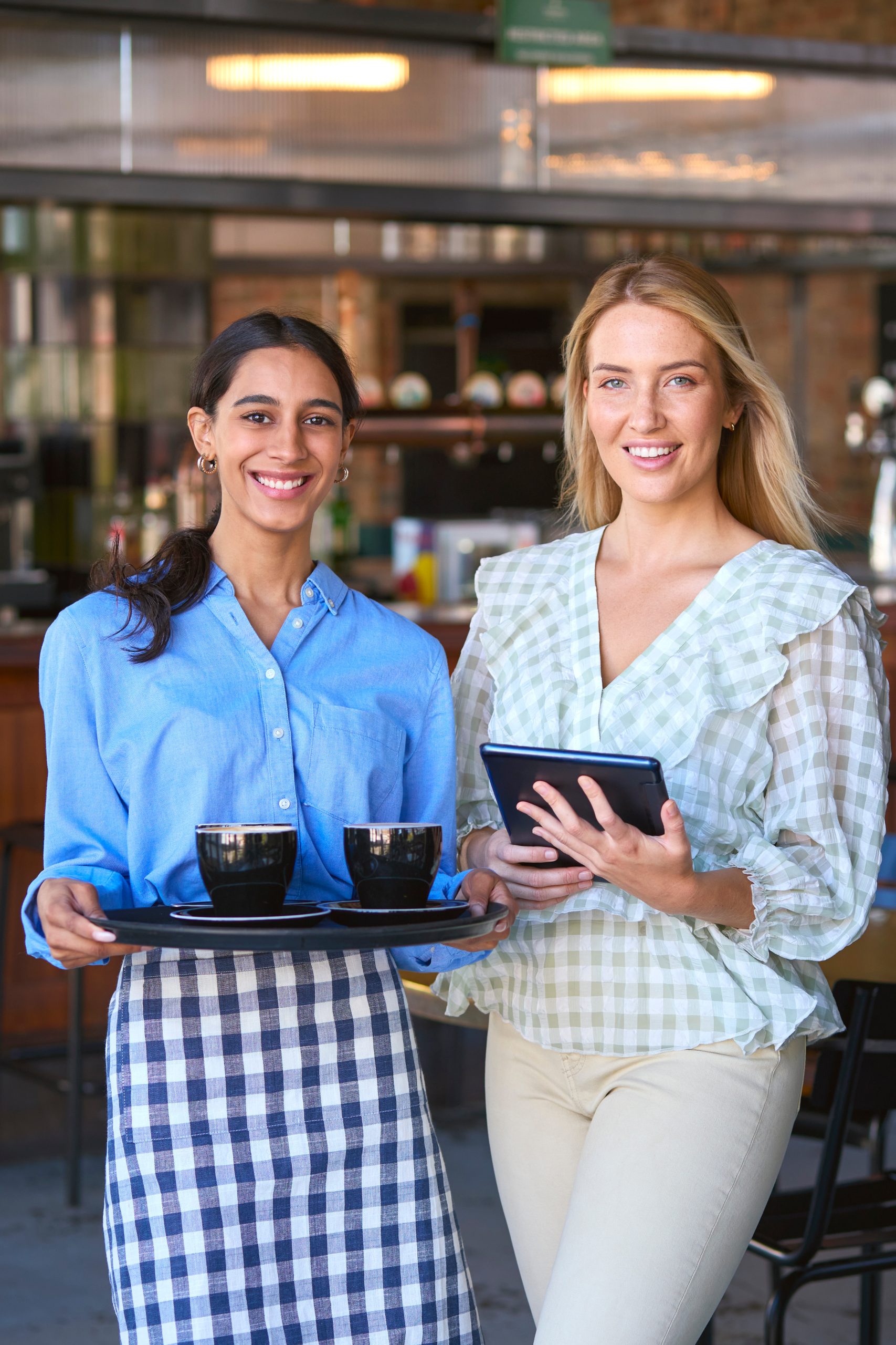 Portrait Of Female Manager With Digital Tablet And Waitress Working In Restaurant Or Coffee Shop