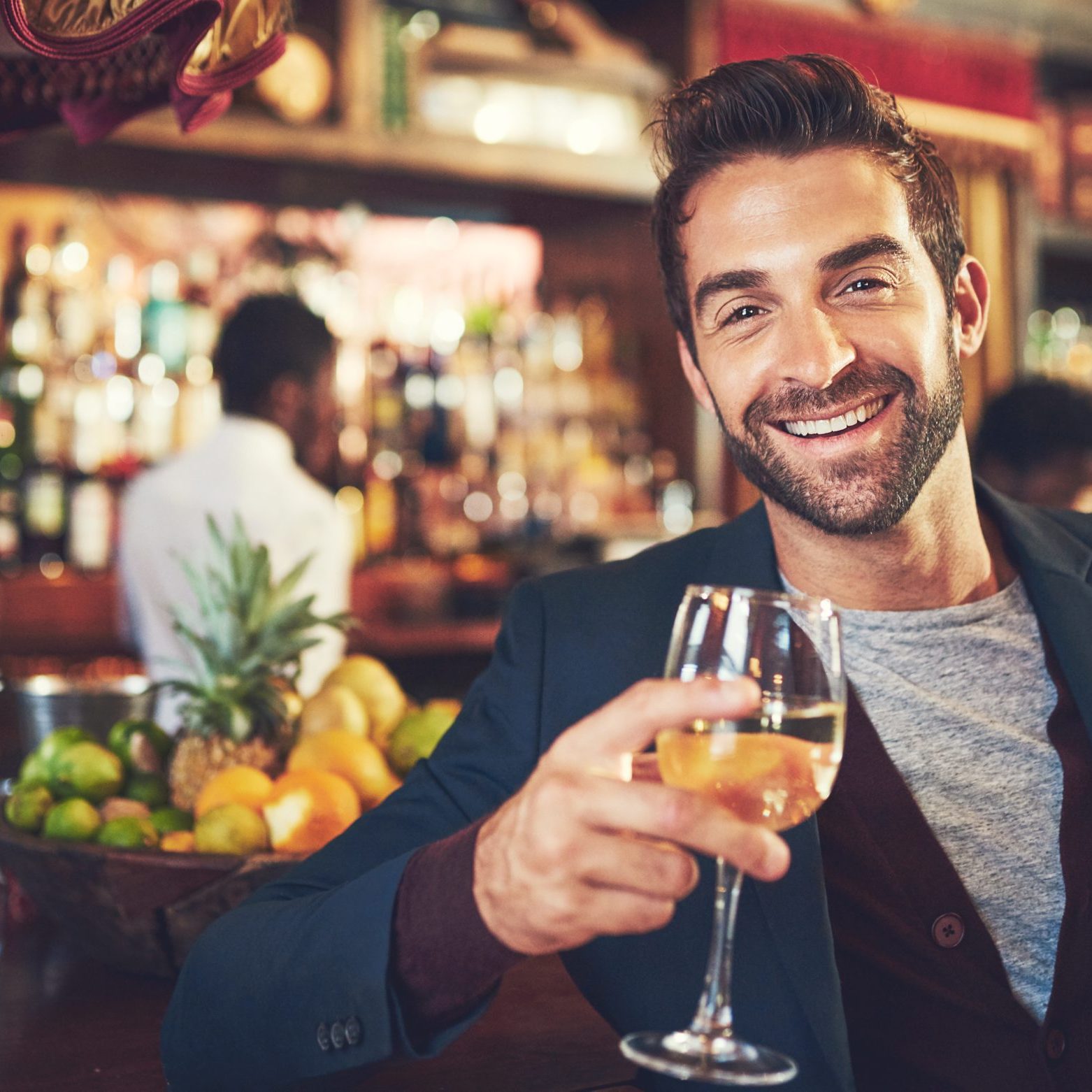 Portrait, wine and man in bar, happiness and stress relief with joy, date and cheers for achievement. Face, person and customer with alcohol, glasses and toast in restaurant, relaxing and excited.
